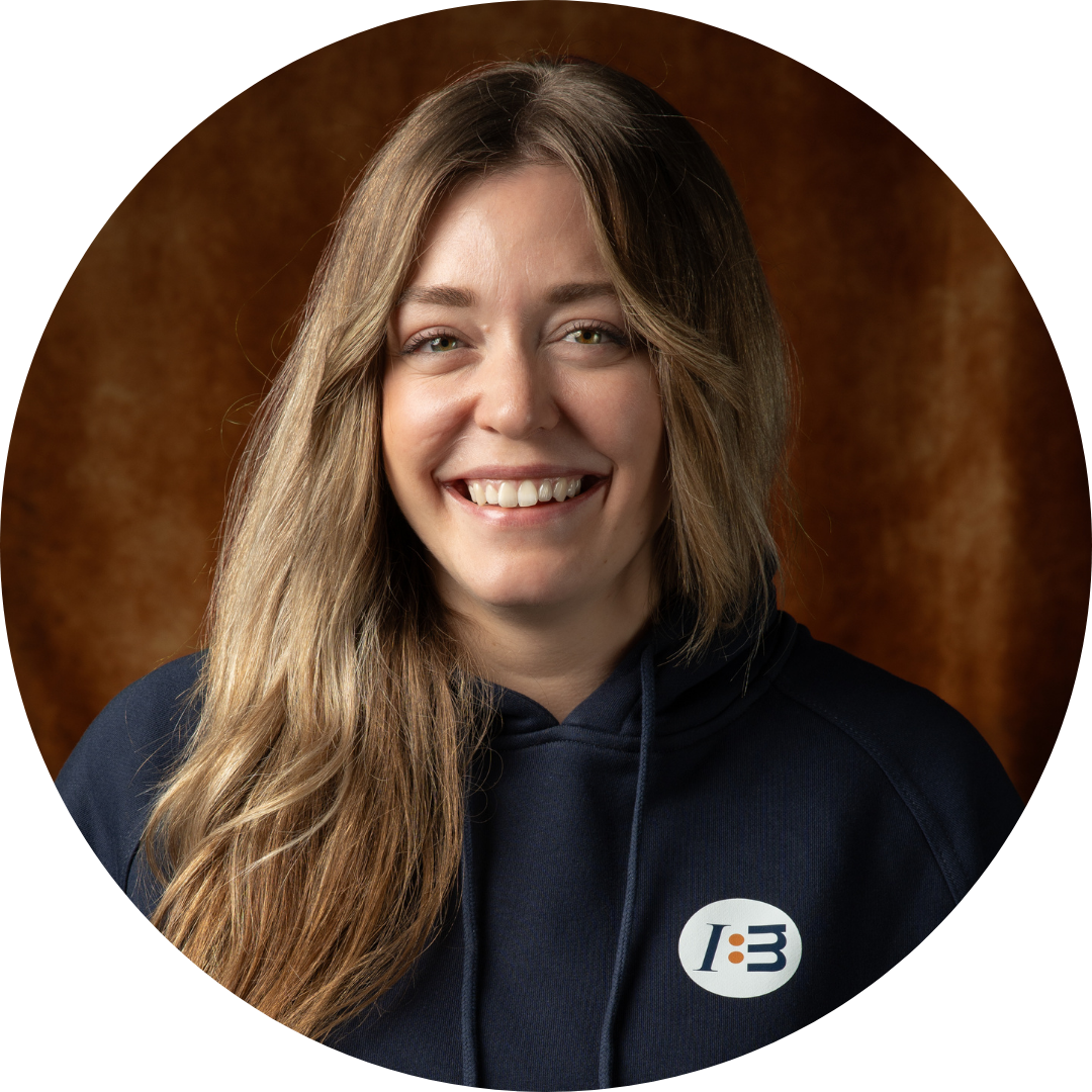 Frau im blauen Hoodie mit Logo lächelt.