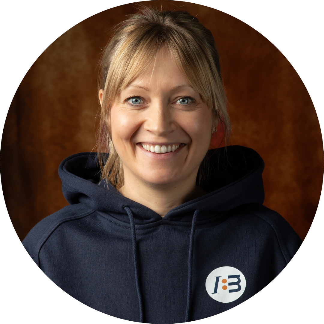 Blonde Frau im blauen Hoodie mit I B Logo.