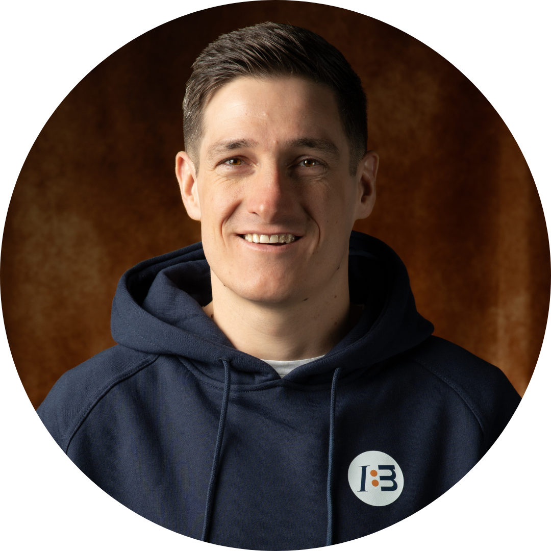 Lächelnde Person in blauem Hoodie mit IB-Logo.